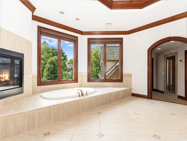 bathroom with baseboards, a glass covered fireplace, ornamental molding, tile patterned flooring, and a bath