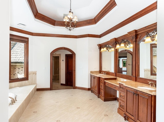 bathroom with ornamental molding, a tray ceiling, a chandelier, and baseboards