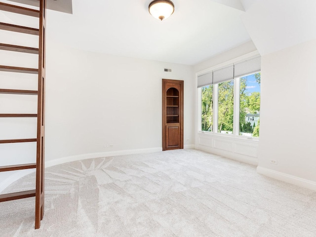 unfurnished room featuring carpet floors, stairway, visible vents, and baseboards