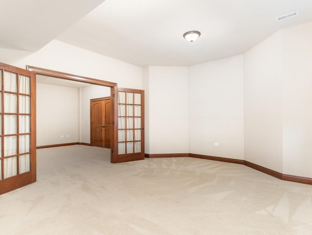 spare room featuring french doors, carpet flooring, visible vents, and baseboards