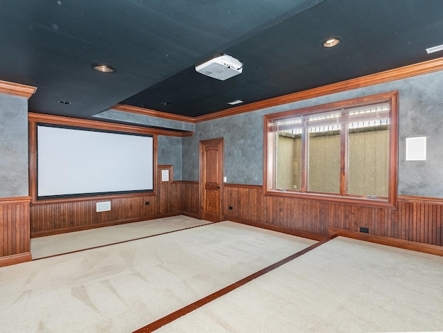 cinema room featuring crown molding, carpet flooring, and wainscoting