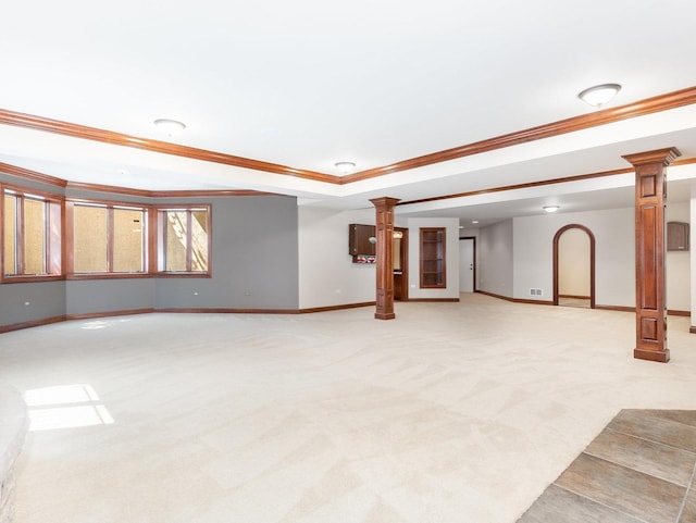 interior space with a tray ceiling, baseboards, light carpet, and ornate columns