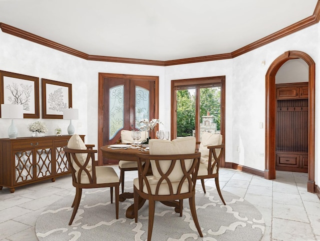 dining area featuring ornamental molding, arched walkways, french doors, and baseboards