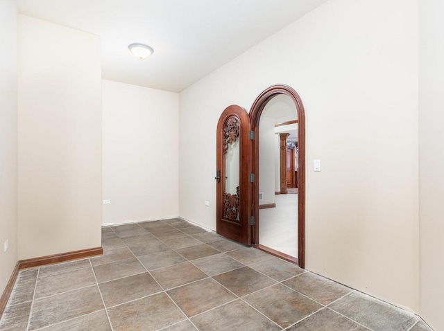 corridor featuring tile patterned flooring and arched walkways