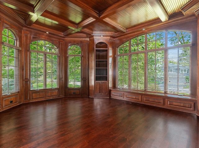 empty room with built in shelves, dark wood-style flooring, coffered ceiling, wood ceiling, and ornamental molding