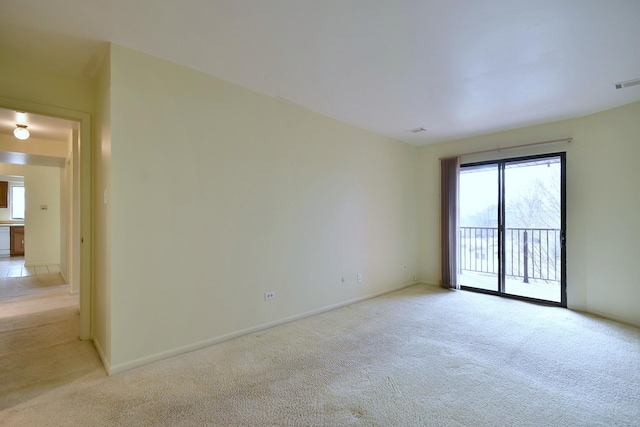 unfurnished room featuring baseboards, visible vents, and light colored carpet