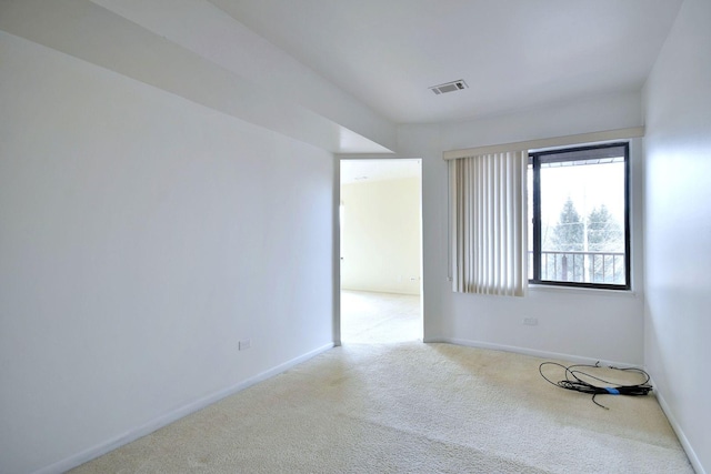 spare room with visible vents, baseboards, and light colored carpet