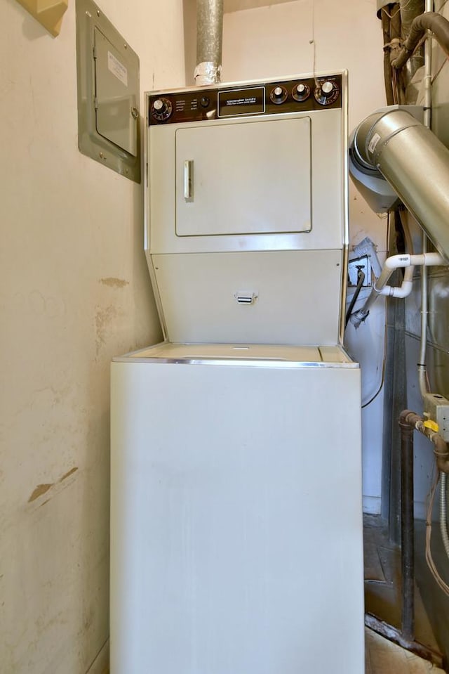 laundry room featuring stacked washer / drying machine, laundry area, and electric panel