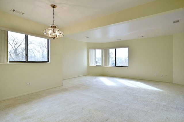 unfurnished room with light colored carpet, visible vents, a notable chandelier, and baseboards