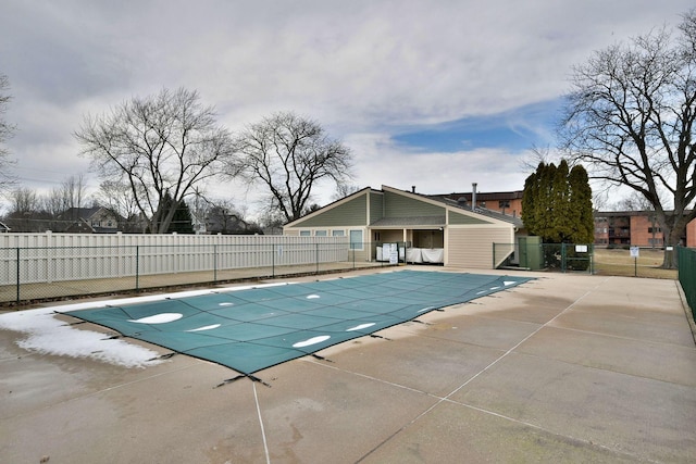 community pool with a patio area and fence