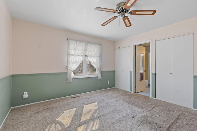 unfurnished bedroom featuring carpet floors, visible vents, and a ceiling fan