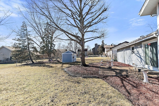 view of yard featuring entry steps, a fenced backyard, a storage shed, an outdoor structure, and a residential view