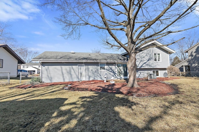 rear view of house featuring central AC, a yard, and fence