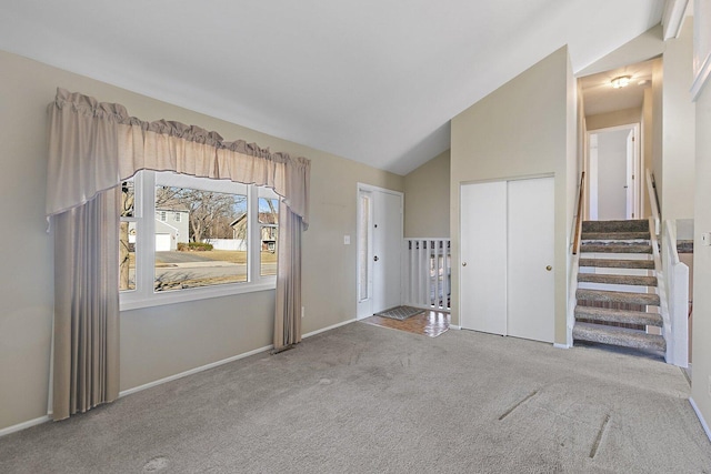 interior space featuring lofted ceiling, light carpet, stairs, and baseboards