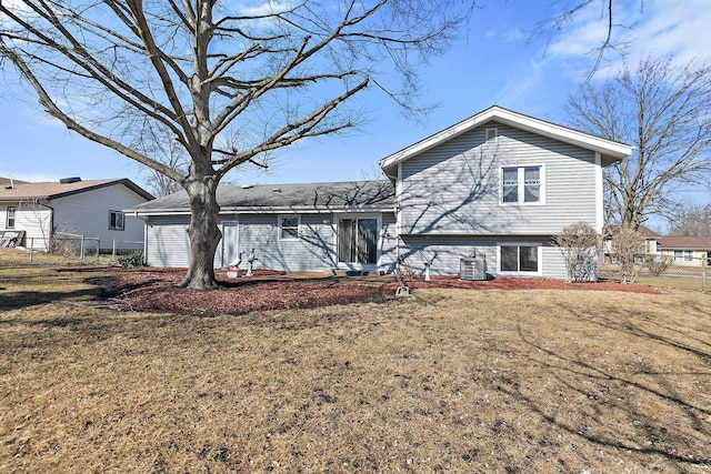 back of property featuring central air condition unit, fence, and a lawn