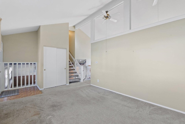 empty room with light colored carpet, ceiling fan, stairs, high vaulted ceiling, and beam ceiling