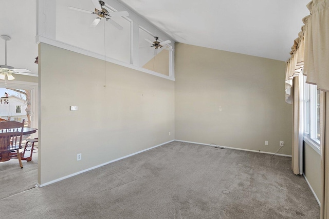 spare room with ceiling fan, high vaulted ceiling, baseboards, and light colored carpet