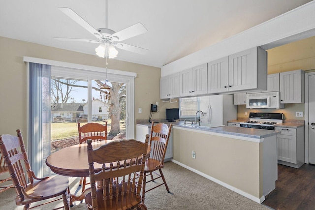 dining area with a ceiling fan, lofted ceiling, and baseboards