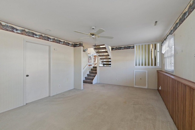 interior space with stairs, ceiling fan, light carpet, and visible vents