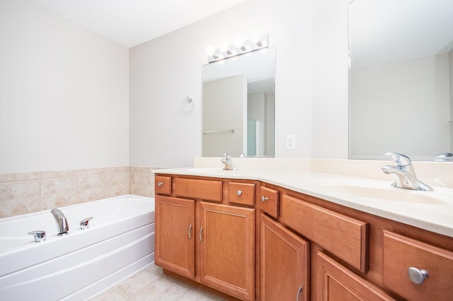 bathroom with double vanity, tile patterned flooring, a sink, and a bath