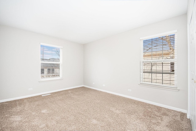 carpeted empty room with visible vents and baseboards