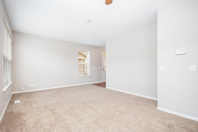 carpeted empty room featuring baseboards