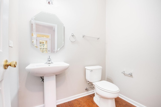 bathroom with wood finished floors, toilet, and baseboards