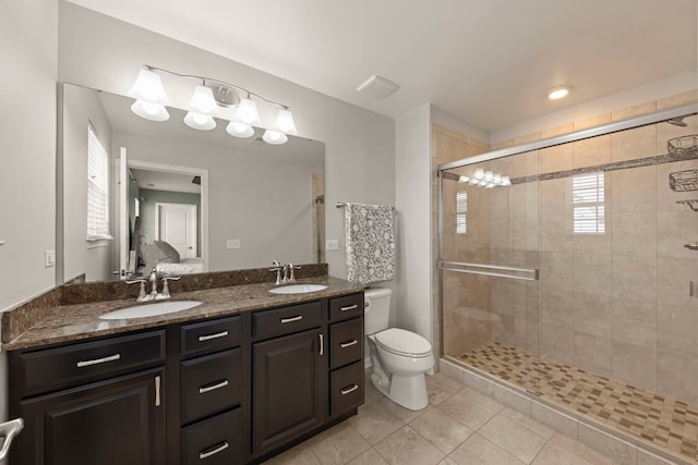 bathroom featuring double vanity, a sink, toilet, and tile patterned floors