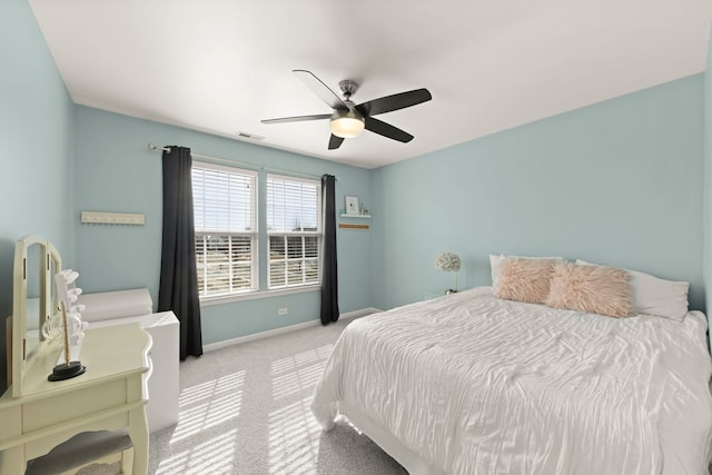 bedroom featuring a ceiling fan, visible vents, light carpet, and baseboards