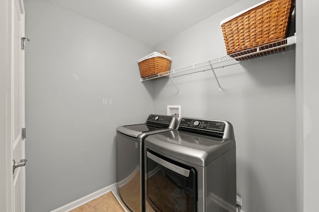 laundry area featuring laundry area, washing machine and clothes dryer, and baseboards