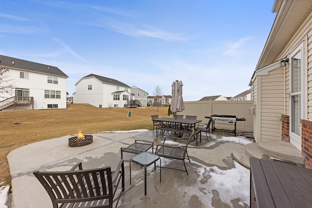 view of patio with outdoor dining area, area for grilling, an outdoor fire pit, fence, and a residential view