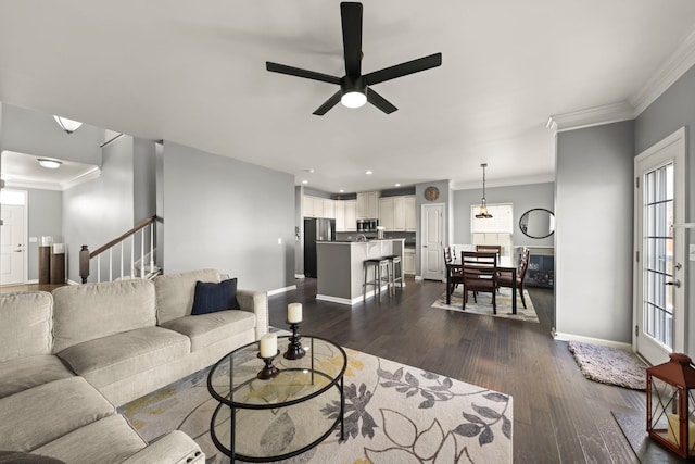 living area with stairway, dark wood-type flooring, ornamental molding, plenty of natural light, and baseboards