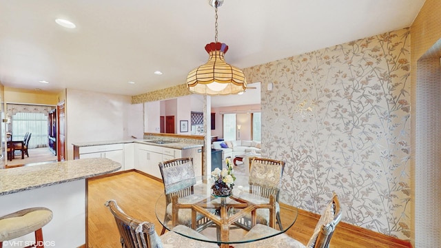 dining room with recessed lighting, wood finished floors, and wallpapered walls