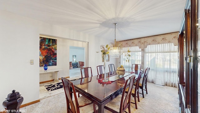 dining room featuring baseboards and an inviting chandelier