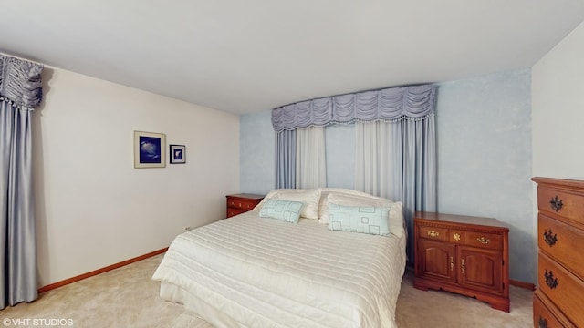 bedroom featuring light carpet and baseboards