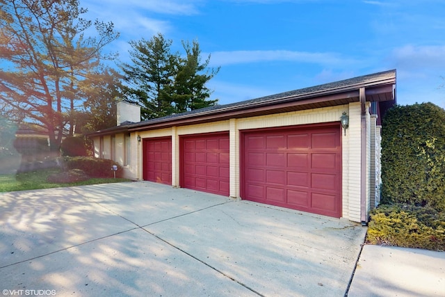 garage featuring concrete driveway