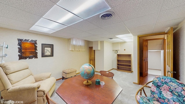 living room with light carpet, baseboards, visible vents, and a paneled ceiling