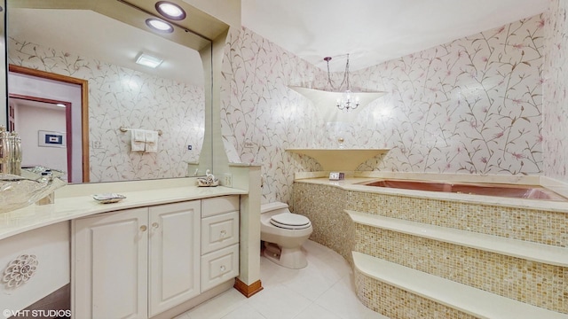 bathroom with a bath, vanity, toilet, and wallpapered walls