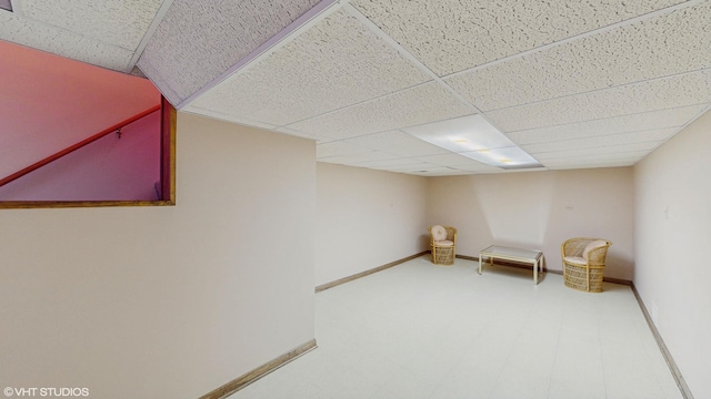 unfurnished room with a paneled ceiling and baseboards