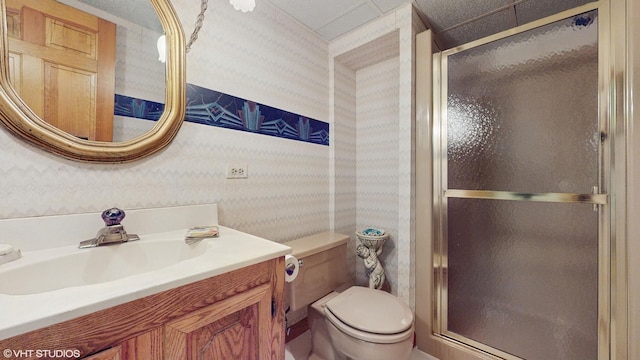 full bath with toilet, a stall shower, wallpapered walls, and vanity