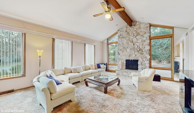 living area with visible vents, a ceiling fan, lofted ceiling with beams, a stone fireplace, and carpet floors