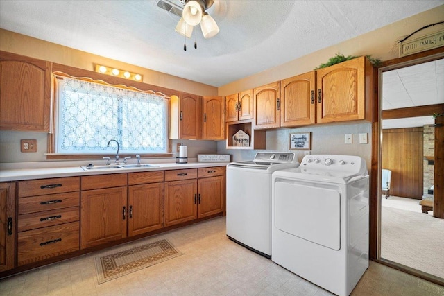 laundry area with washer and dryer, a sink, cabinet space, light floors, and ceiling fan