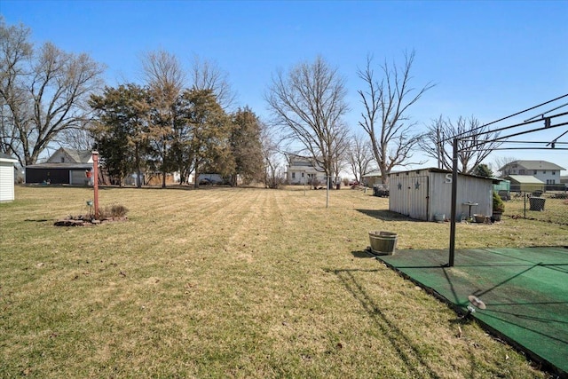 view of yard with an outbuilding, a storage shed, and fence