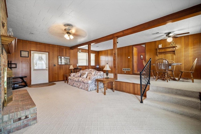 living room featuring carpet flooring, beamed ceiling, and ceiling fan