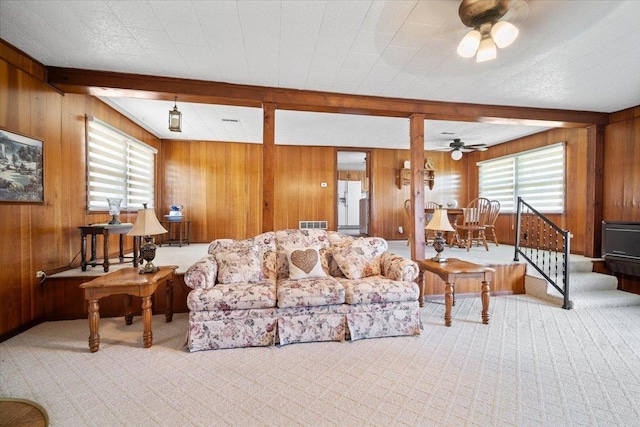 living room with beam ceiling, carpet floors, and ceiling fan