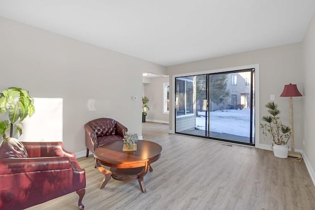 living room featuring baseboards, visible vents, and light wood-style floors