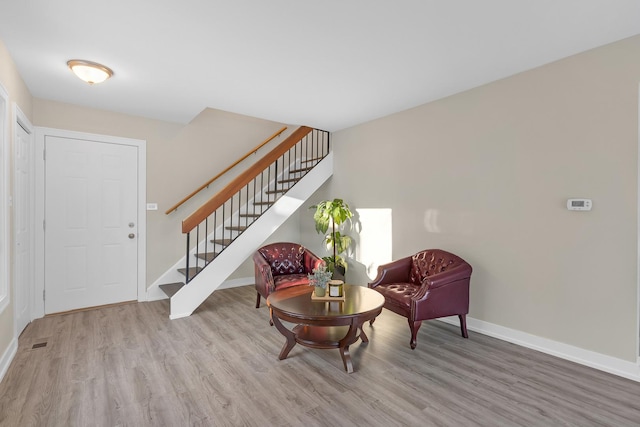 entrance foyer with visible vents, light wood-style flooring, baseboards, and stairs