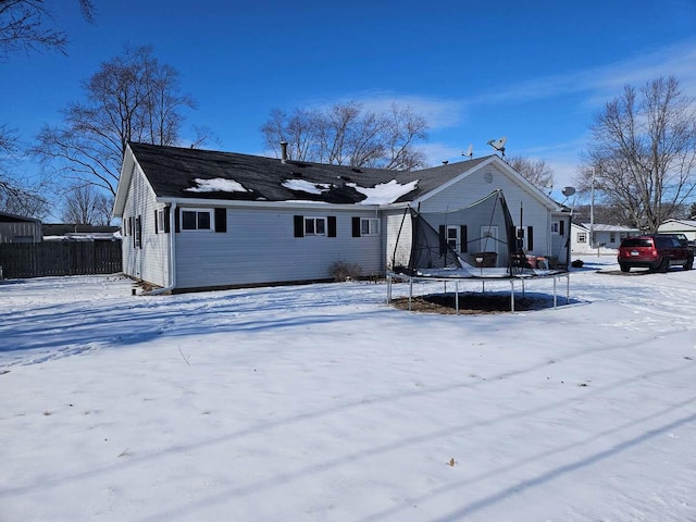 ranch-style house with a trampoline and fence