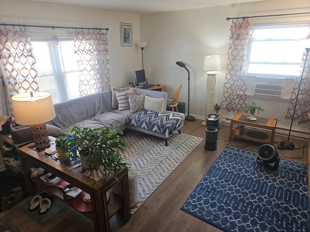 living area featuring baseboards, cooling unit, and wood finished floors