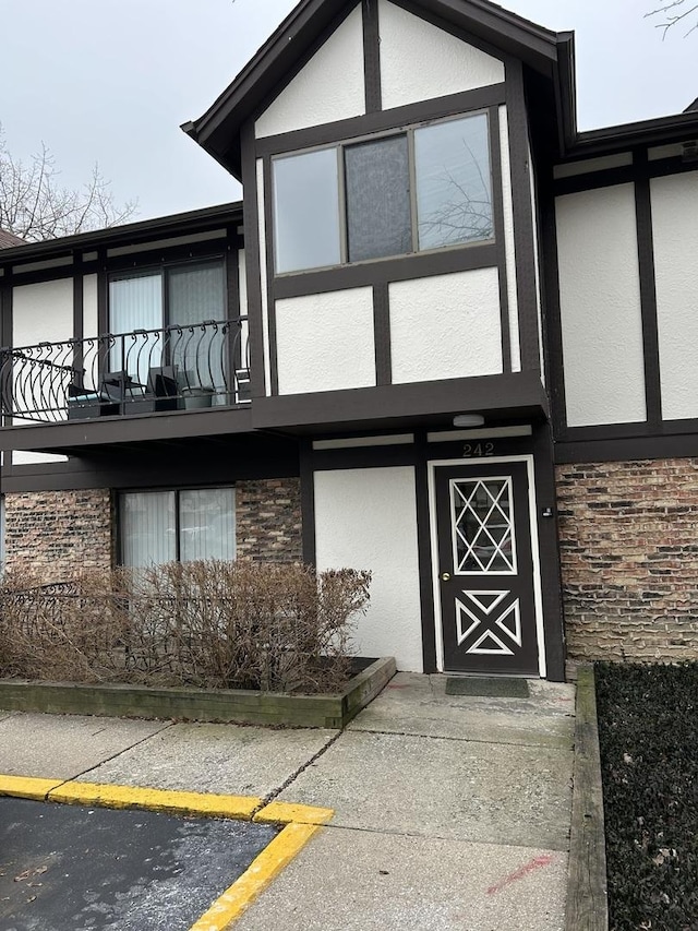 doorway to property featuring a balcony and stucco siding